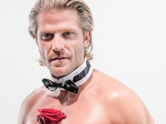 Ex-Bachelor Paul Janke mit nacktem Oberkörper, einer Fliege um den Hals und einer Rose in der Hand.