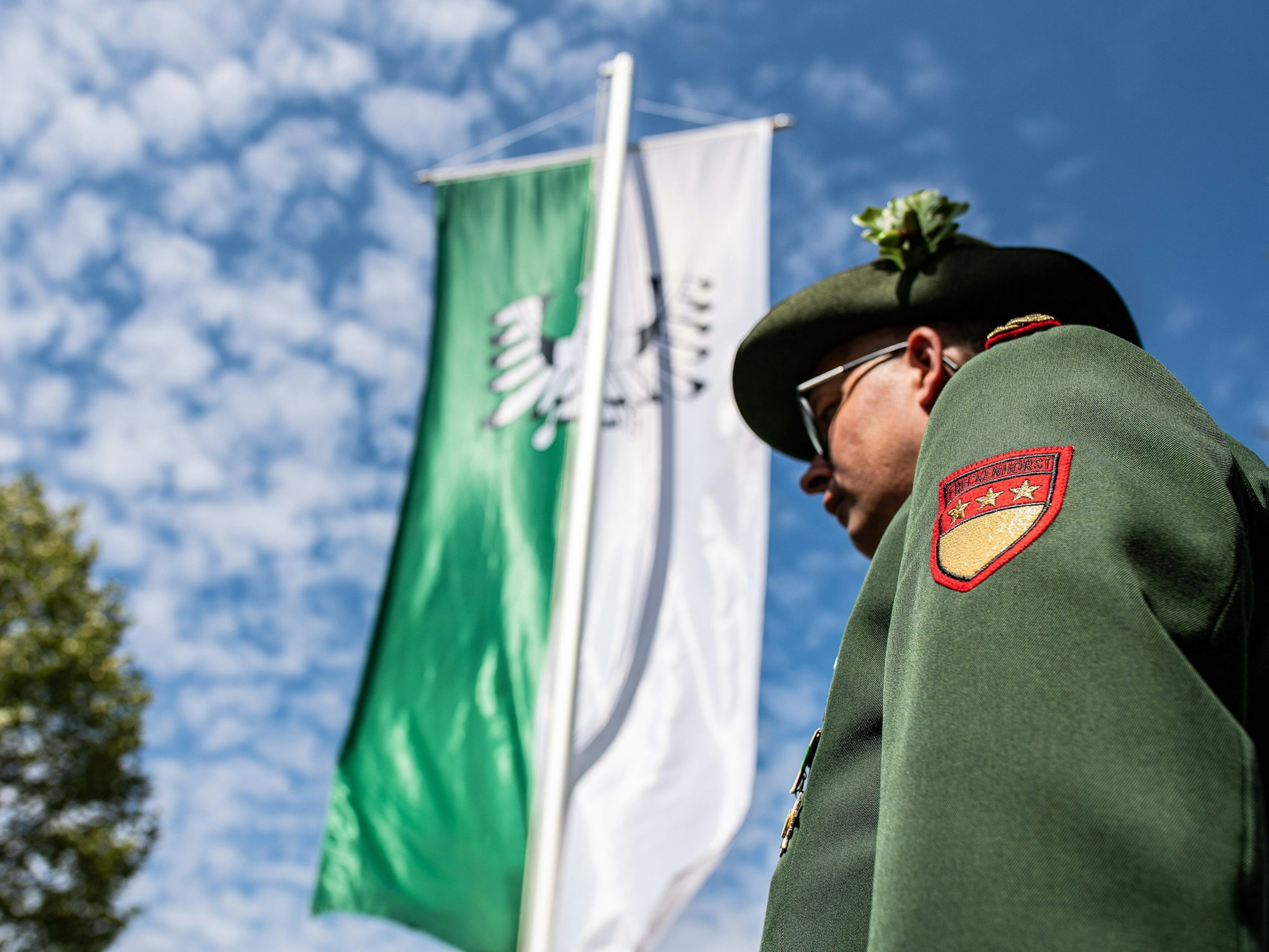 Warendorf: Ein Adjutant der Bürgerschützen Freckenhorst steht vor einer grün-weißen Schützenfahne.