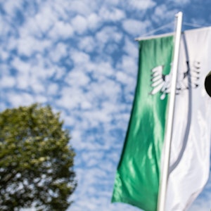 Warendorf: Ein Adjutant der Bürgerschützen Freckenhorst steht vor einer grün-weißen Schützenfahne.