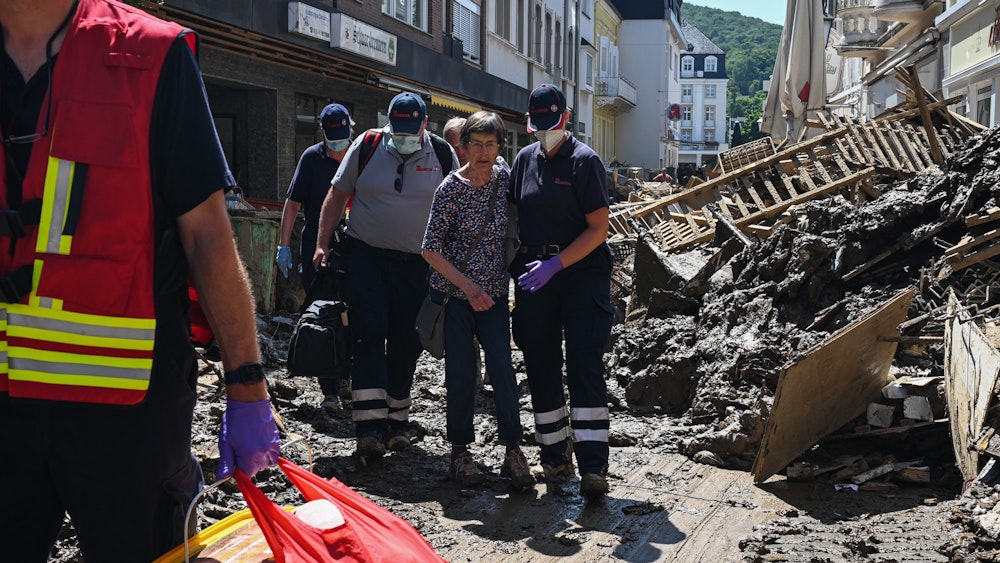 Helfer der Johanniter in Bad Neuenahr-Ahrweiler begleiten nach der Flutkatastrophe eine Seniorin aus ihrer Wohnung.