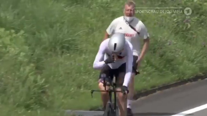 Patrick Moster läuft und ruft Radfahrer Nikias Arndt hinterher.
