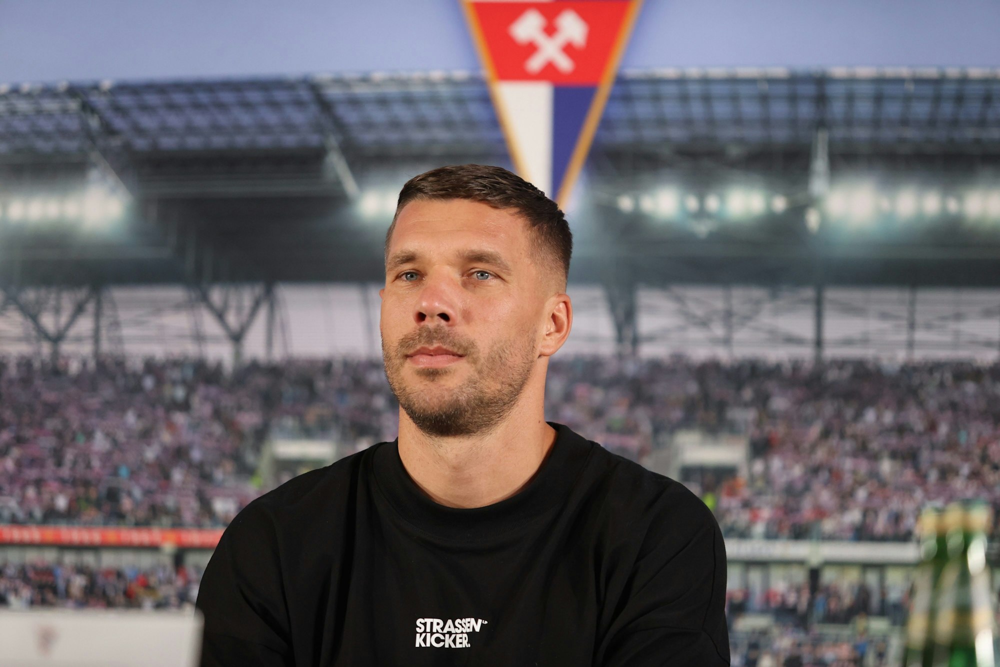 Lukas Podolski aus Deutschland sitzt  bei einer Pressekonferenz zu seiner Vorstellung als Neuzugang beim polnischen Fußball-Erstligisten Gornik Zabrze.