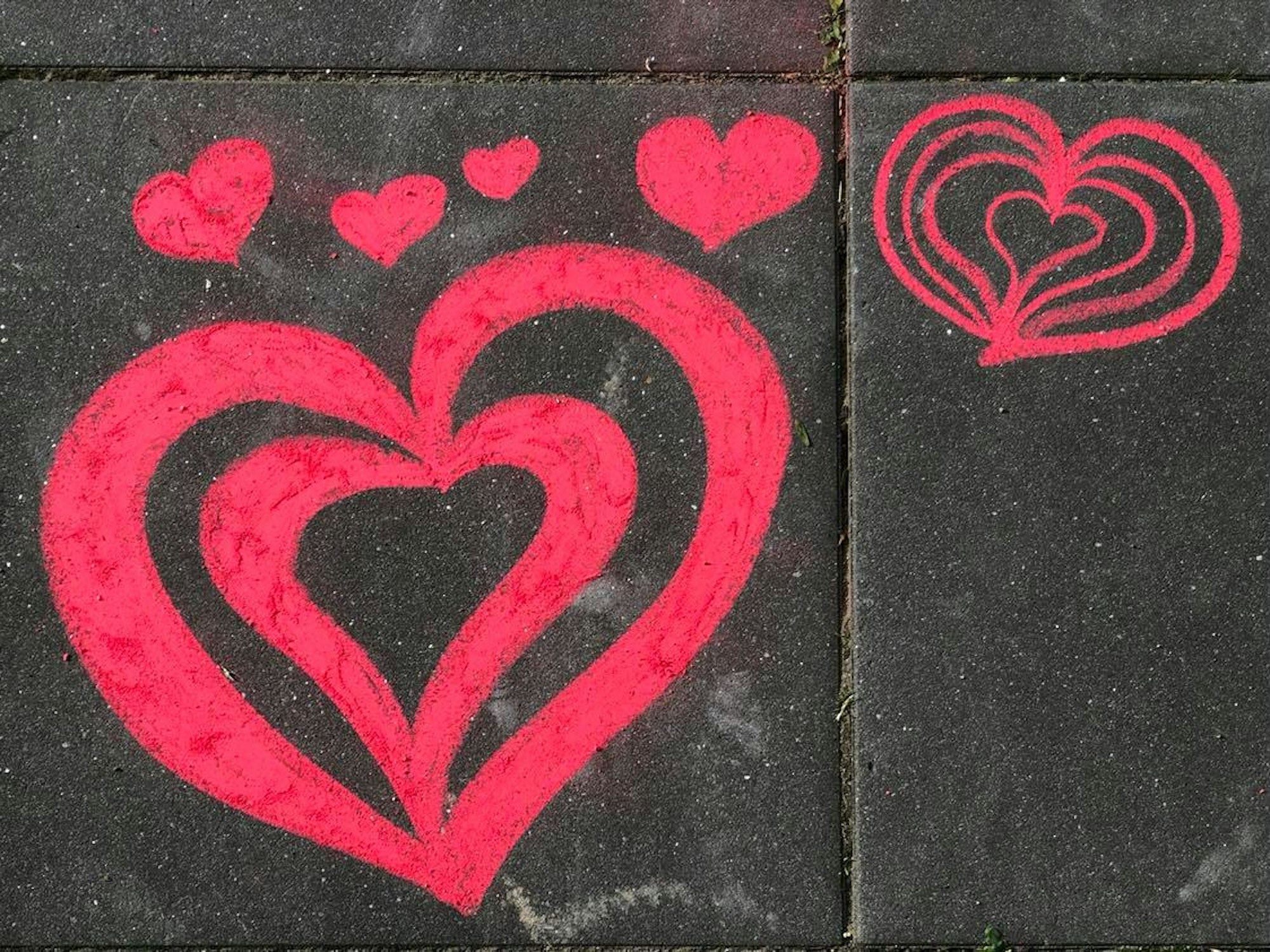 Auf einem Bürgersteig in Köln-Weidenpesch wurden rote Herzen mit EXPRESS-Kreide gemalt.