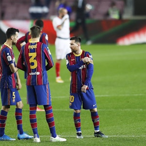 Sergio Busquets und Gerard Pique reden bei einem Spiel des FC Barcelona mit Lionel Messi.