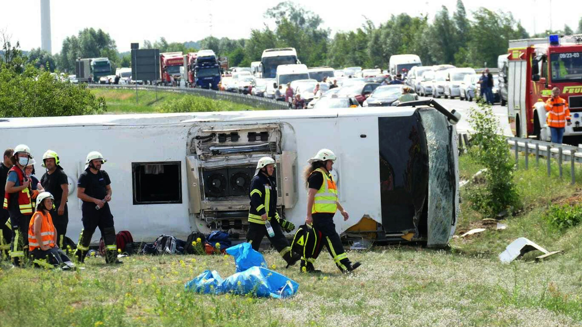 Rettungskräfte sind an der Unfallstelle im Einsatz. Auf der Autobahn 13 bei Schönwald (Dahme-Spreewald) südöstlich von Berlin ist ein Reisebus verunglückt.