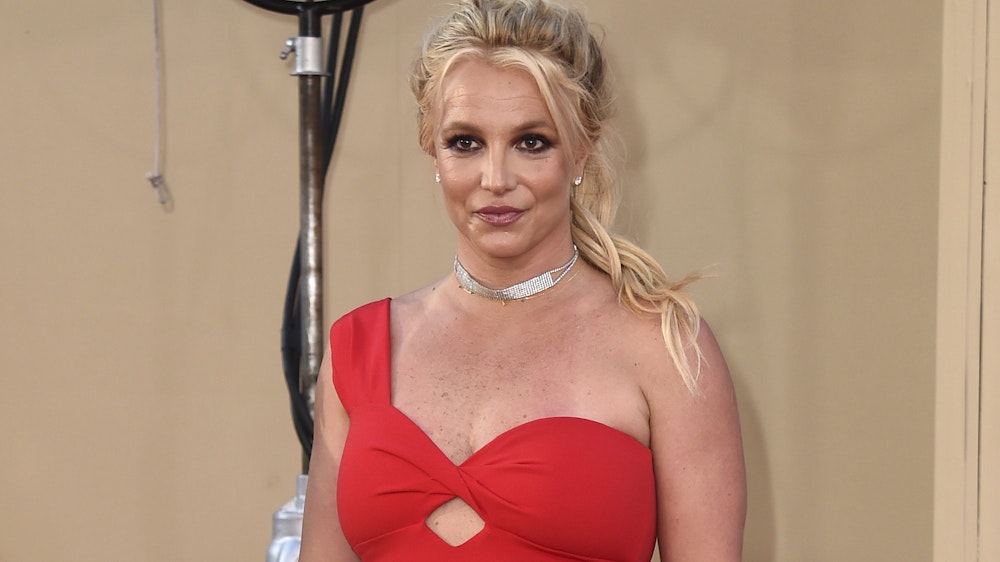 Britney Spears posiert im roten Kleid bei einer Veranstaltung.