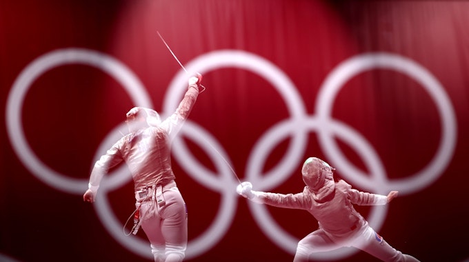 Zwei Fechterinnen duellieren sich, im Vordergrund prangen die Olympischen Ringe.