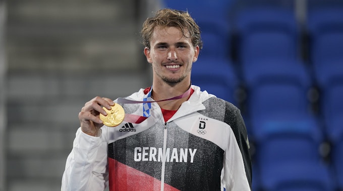 Alexander Zverev hält seine Tennis-Goldmedaille bei der Olympia-Siegerehrung in die Kamera.