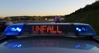 Auf einem Polizeifahrzeug warnt auf der Autobahn A8 eine Leuchtschrift vor einer Unfallstelle.