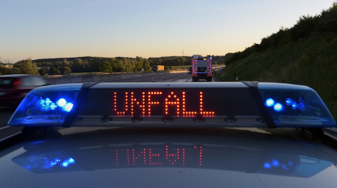 Auf einem Polizeifahrzeug warnt auf der Autobahn A8 eine Leuchtschrift vor einer Unfallstelle.