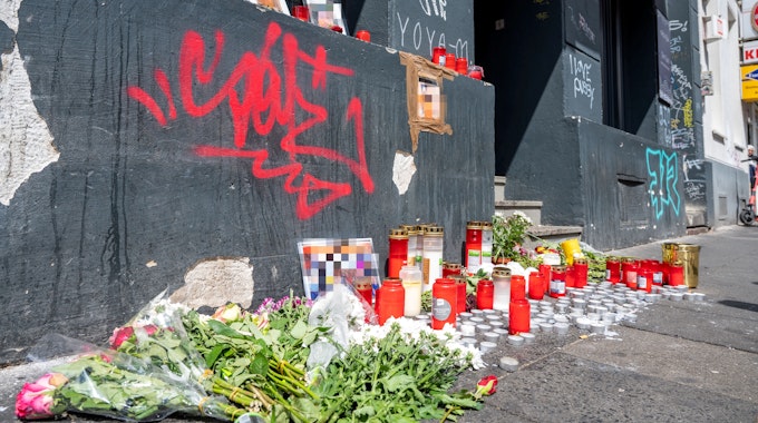 Blumen und Kerzen sind am Tatort auf der Zülpicher Straße niedergelegt.