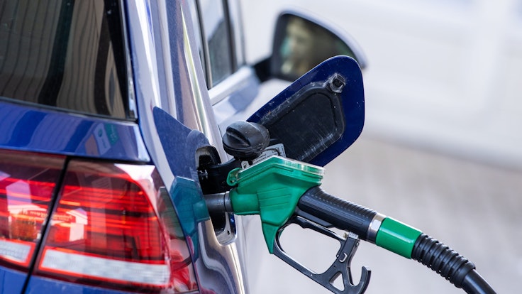 Spritpreise steigen: Eine Zapfpistole für Super-Kraftstoff steckt in einer Tankstelle im Tankstutzen eines Autos.
