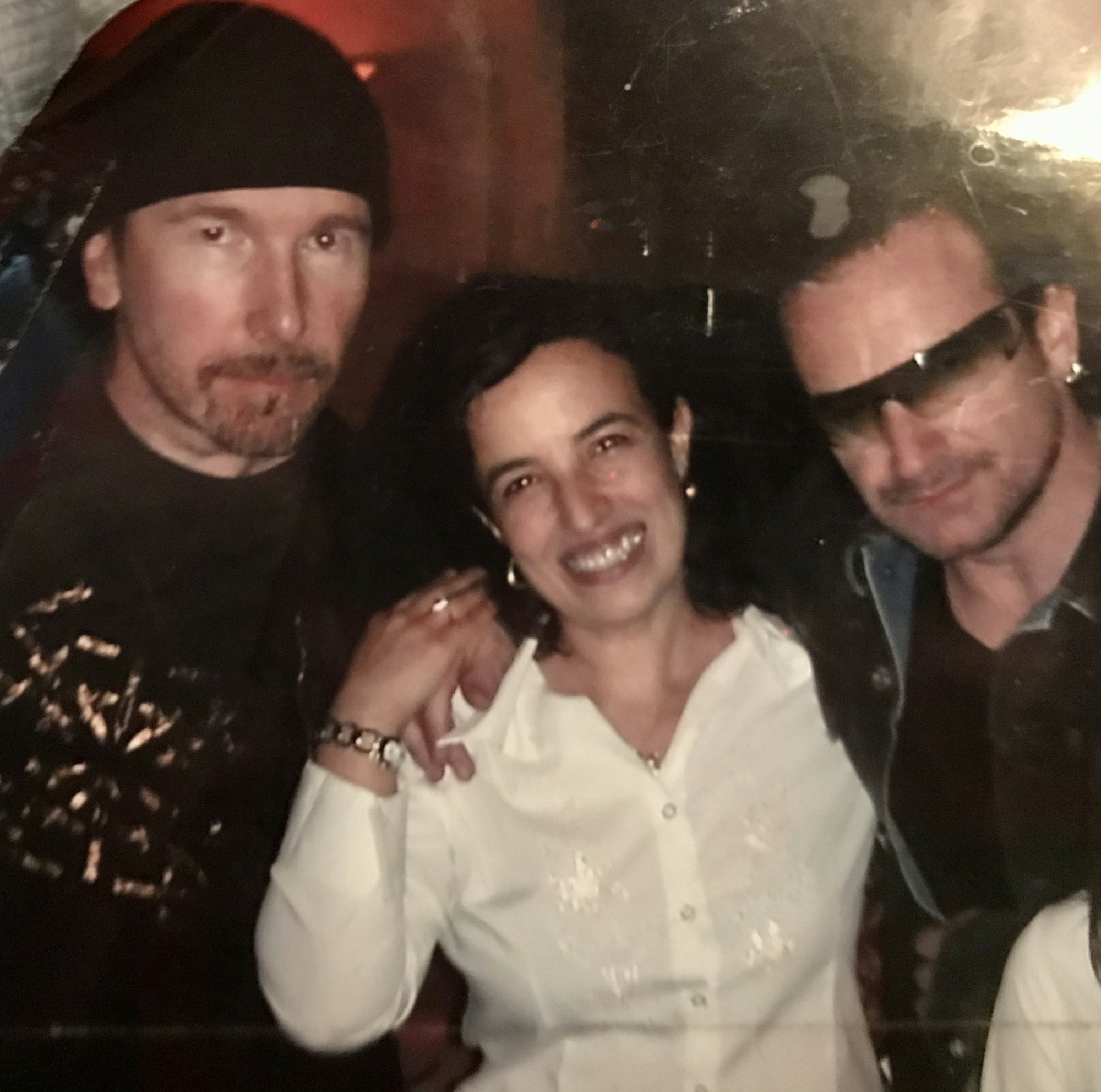 Bono und The Edge von U2 halten Wirtin Filippa im Arm.
