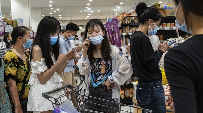 Menschen in einem Supermarkt im chinesischen Wuhan tragen am 02.08. Mund-Nasenschutz-Masken.
