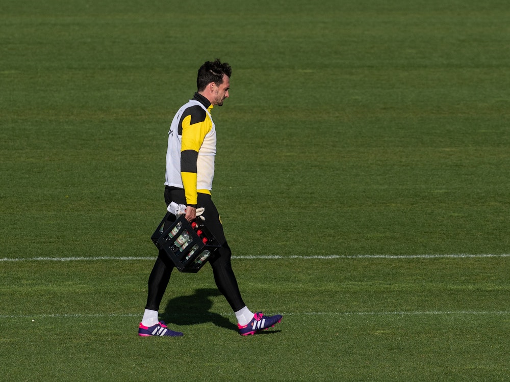 Mats Hummels trägt am Ende des Training von Borussia Dortmund am 4. Mai die Wasserkästen vom Platz.