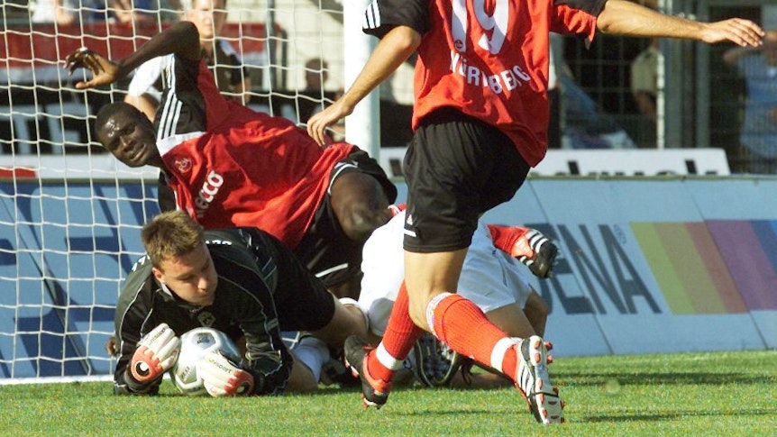Torwart Holger Betz (Ulm, u) rettet den Ball vor den beiden Nürnbergern Louis Gomis (l) und Marco Villa (r) in der ersten Hauptrunde des DFB-Pokals.