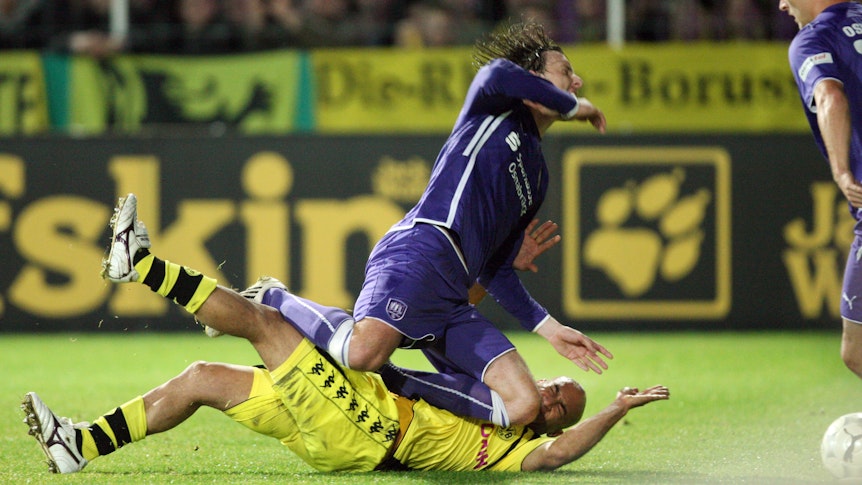 Dede wird beim Pokalspiel zwischen dem VfL Osnabrück und Borussia Dortmund im Zweikampf von Henrich Bencik abgeräumt