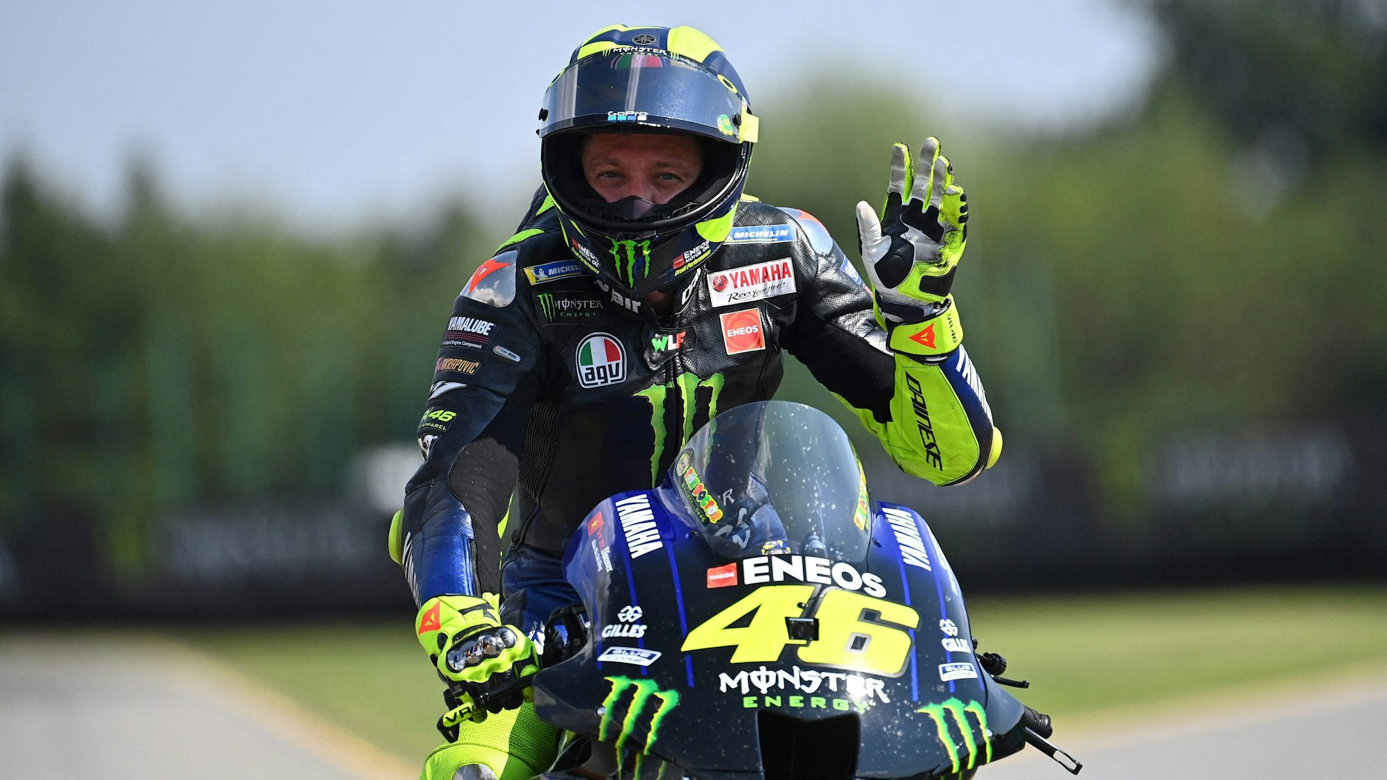 Valentino Rossi winkt nach einem MotoGP-Rennen auf seinem Motorrad.