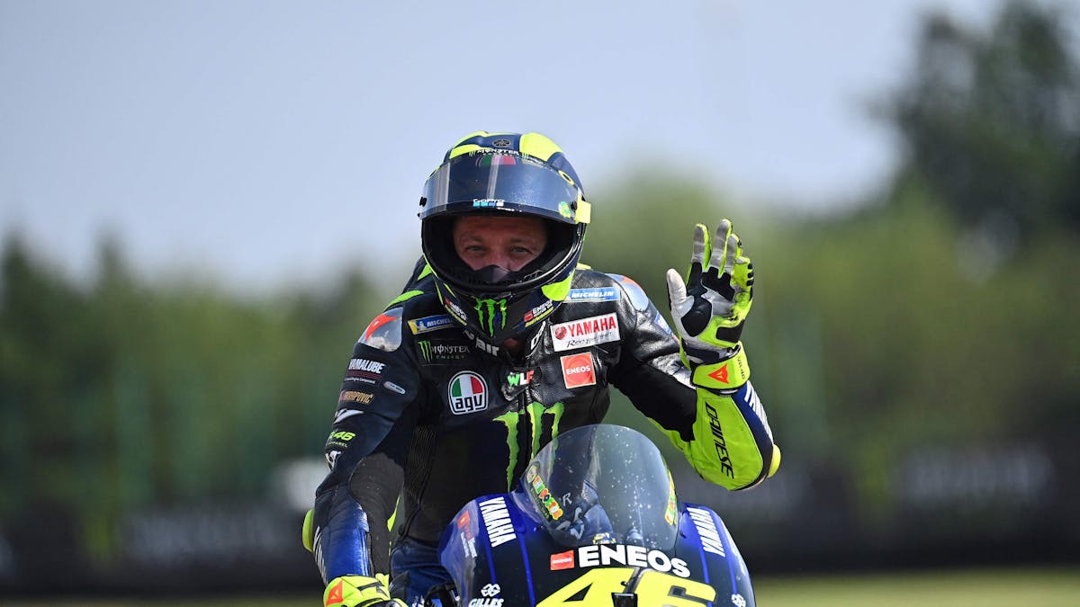Valentino Rossi winkt nach einem MotoGP-Rennen auf seinem Motorrad.