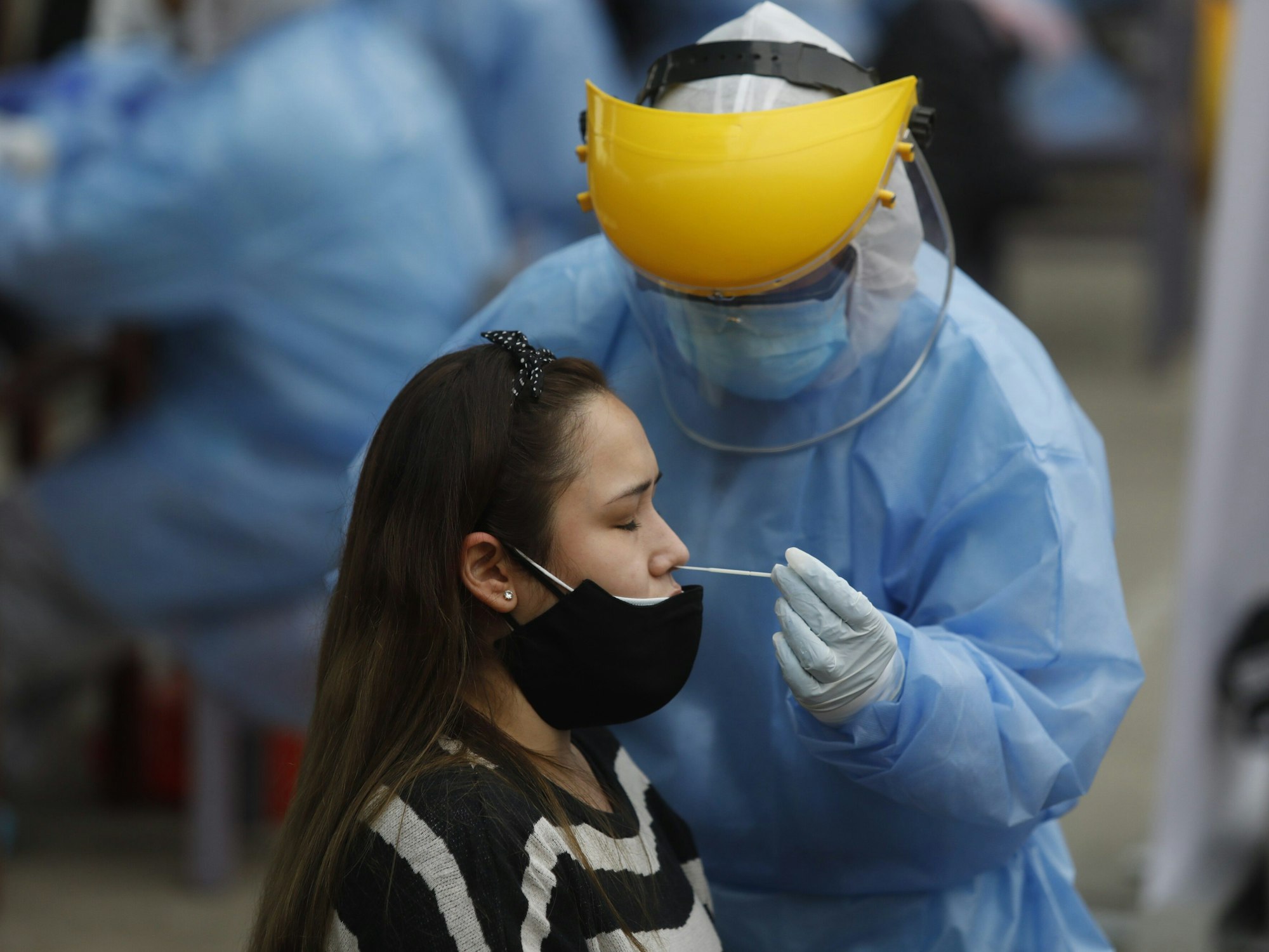Peru, Lima: Ein medizinischer Mitarbeiter nimmt einen Corona-Nasenabstrich.