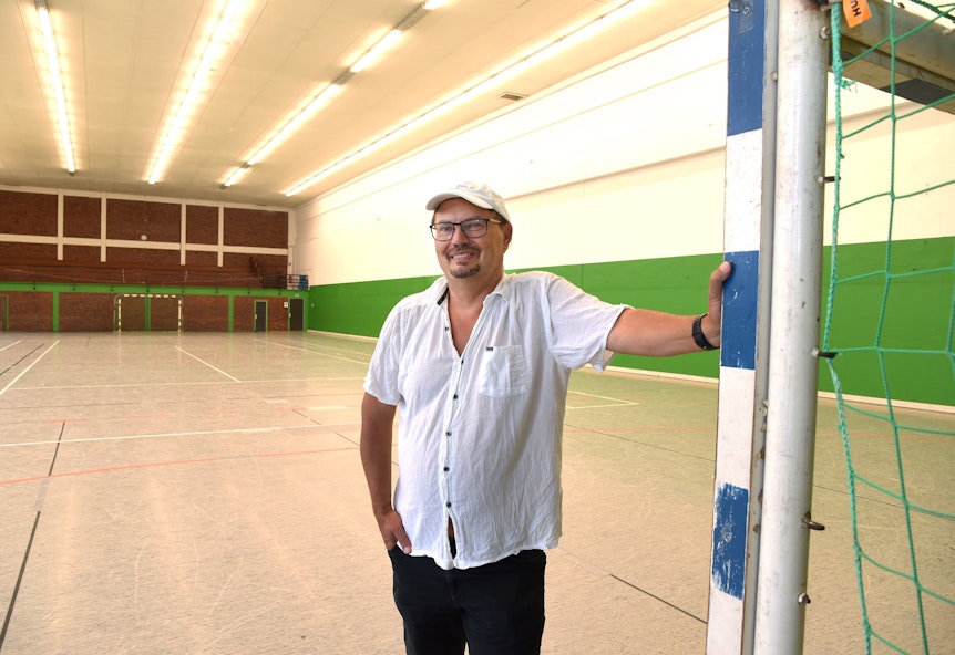 Guido Sadlo, 1. Vorsitzender des ESV Olympia e.V., lehnt sich in der Olympiahalle an einen Pfosten des Handballtors.