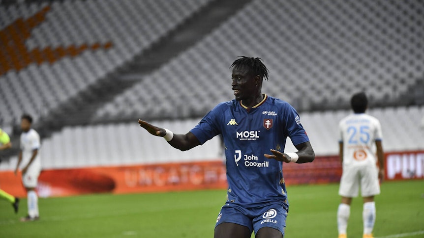 Ibrahima Niane im blauen Trikot des FC Metz mit angewinkelten Armen in einer Jubelpose und dem Blick zur Seite.