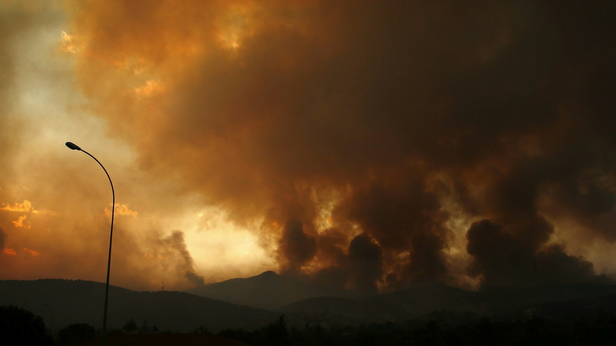 Dunkle Rauchwolken steigen 35 Kilometer entfernt von Athen in den Himmel, Grund dafür sind die anhaltenden Waldbrände.