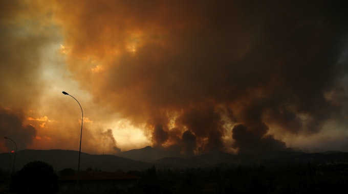 Dunkle Rauchwolken steigen 35 Kilometer entfernt von Athen in den Himmel, Grund dafür sind die anhaltenden Waldbrände.