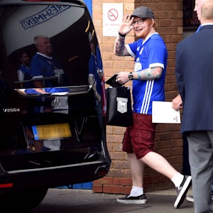 Ed Sheeran winkt mit einem Trikot des englischen Drittligisten Ipswich Town in die Kamera.