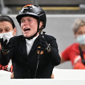 Annika Schleu hebt beim Springreit-Wettbewerb des Olympischen Fünfkampfes in Tokio klagend die Arme.