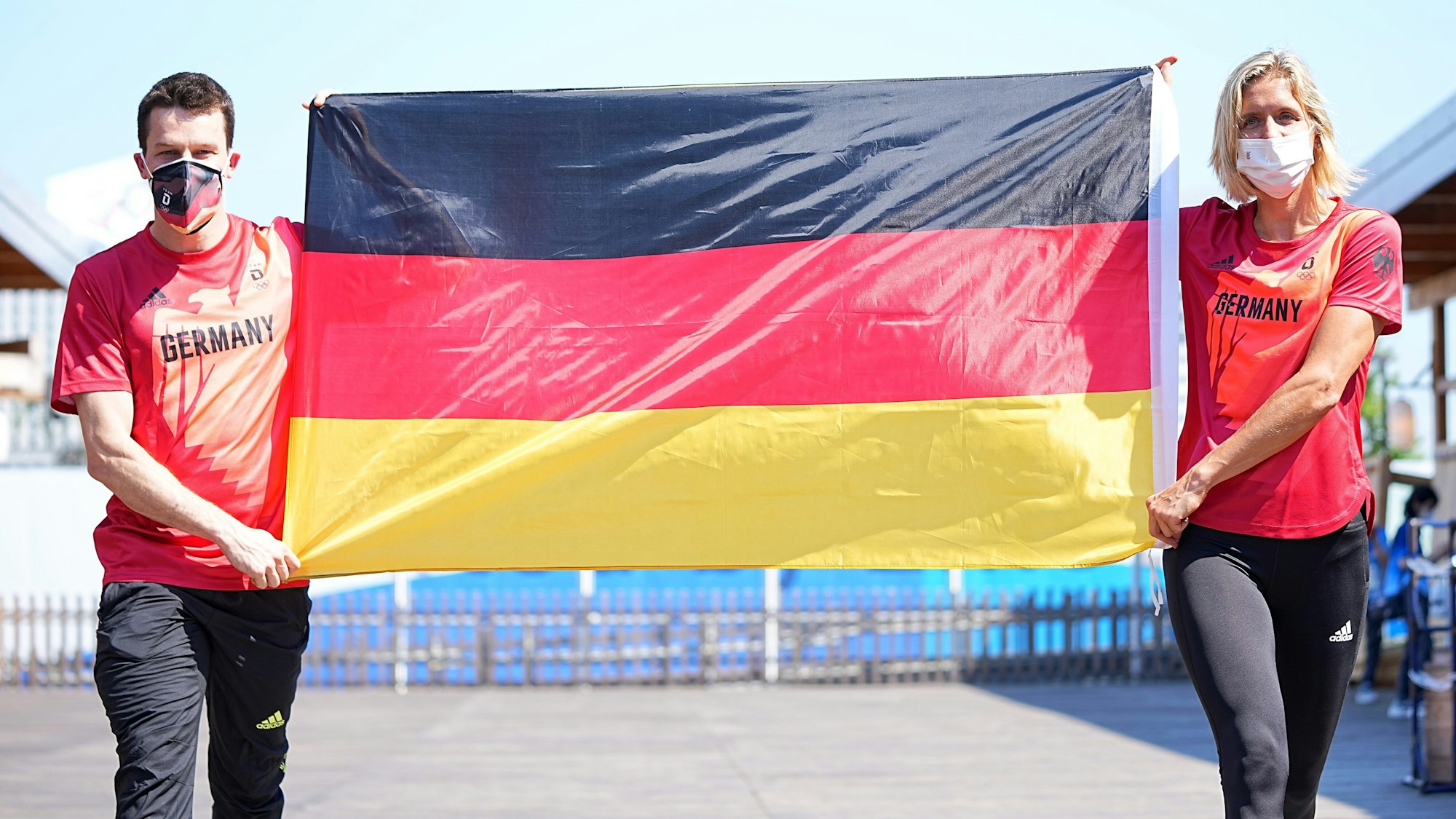 Patrick Hausding und Laura Ludwig halten eine Deutschland-Fahne