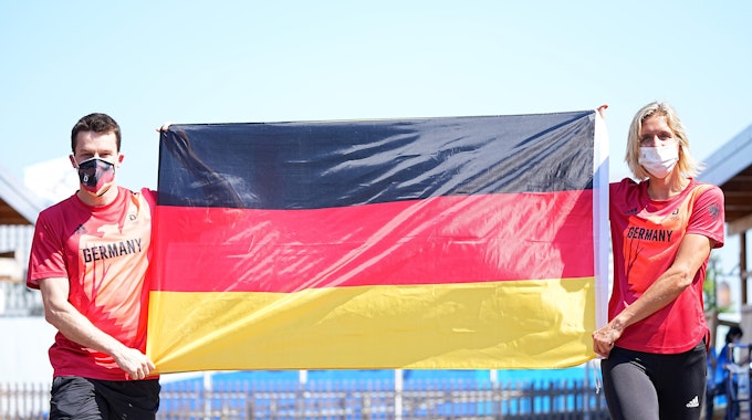 Patrick Hausding und Laura Ludwig halten eine Deutschland-Fahne