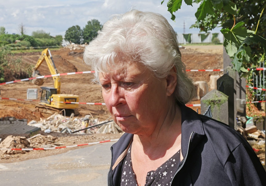 Maria Dunkel, Anwohnerin in Erftstadt-Blessem, steht an der Abbruchkante zum Krater neben der Kiesgrube. Hier tat sich nach der Flut-Katastrophe die Erde auf.