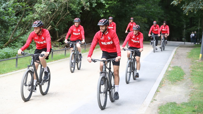 Die Spieler des 1. FC Köln fahren Fahrrad.