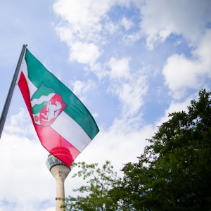 Eine Flagge mit dem Landeswappen von Nordrhein-Westfalen weht vor der Staatskanzlei in Düsseldorf.