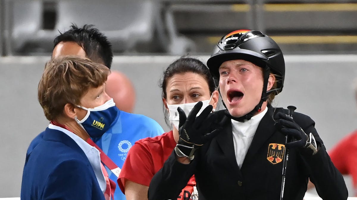 Annika Schleu (r) aus Deutschland weint bei Olympia, weil ihr Pferd mehrmals den Sprung verweigerte.