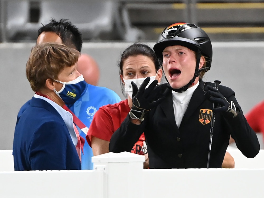 Annika Schleu (r) aus Deutschland weint bei Olympia, weil ihr Pferd mehrmals den Sprung verweigerte.