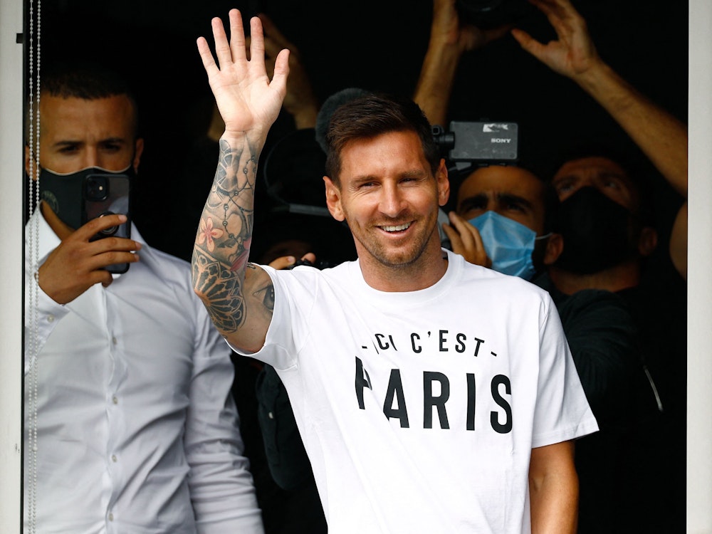 Lionel Messi winkt bei seiner Vorstellung in Paris in die Menge.