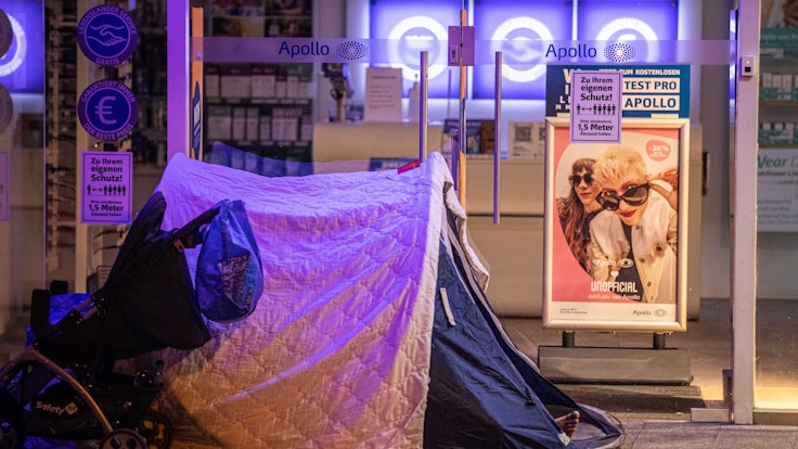 Ein Obdachloser hat sein Zelt vor einem Geschäft in Köln aufgeschlagen.