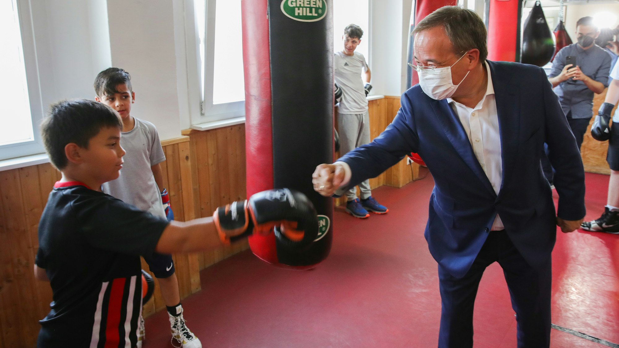 Armin Laschet (CDU, r), Ministerpräsident des Landes Nordrhein-Westfalen und Kanzlerkandidat, boxt im Rahmen eines Termins seiner Wahlkampftour, mit einem Jungen im Boxcamp Gallus, in dem Kinder und Jugendliche trainieren.