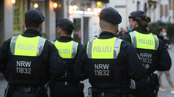 Polizisten einer Hundertschaft gehen in der Düsseldorfer Altstadt Streife.