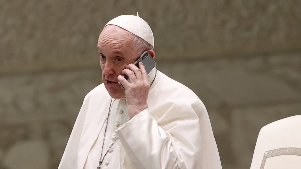Papst Franziskus spricht am Ende seiner wöchentlichen Generalaudienz in der Halle Paul VI. in ein Telefon.&nbsp;