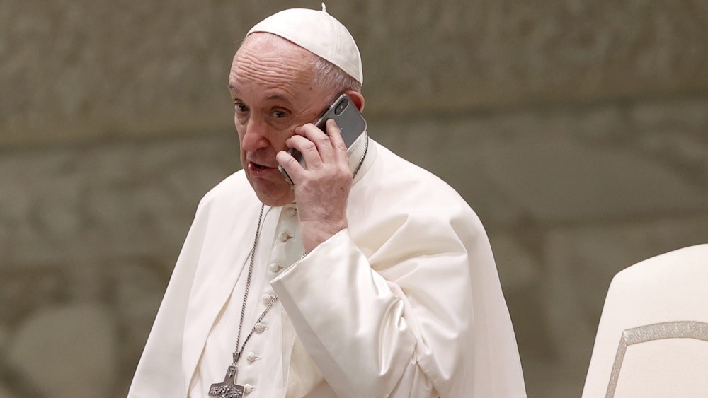Papst Franziskus spricht am Ende seiner wöchentlichen Generalaudienz in der Halle Paul VI. in ein Telefon.
