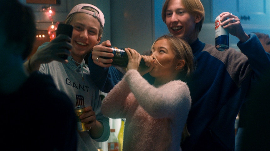 Drei Jugendliche trinken Alkohol und filmen sich dabei mit dem Handy.