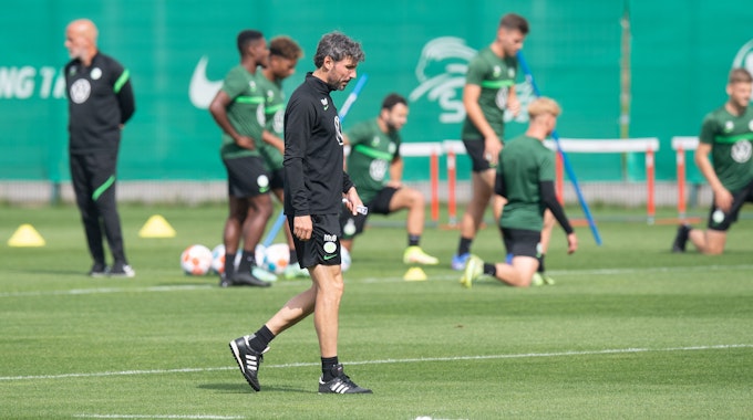 Mark van Bommel, Trainer VfL Wolfsburg, geht beim Training am 11. August 2021 über den Platz.