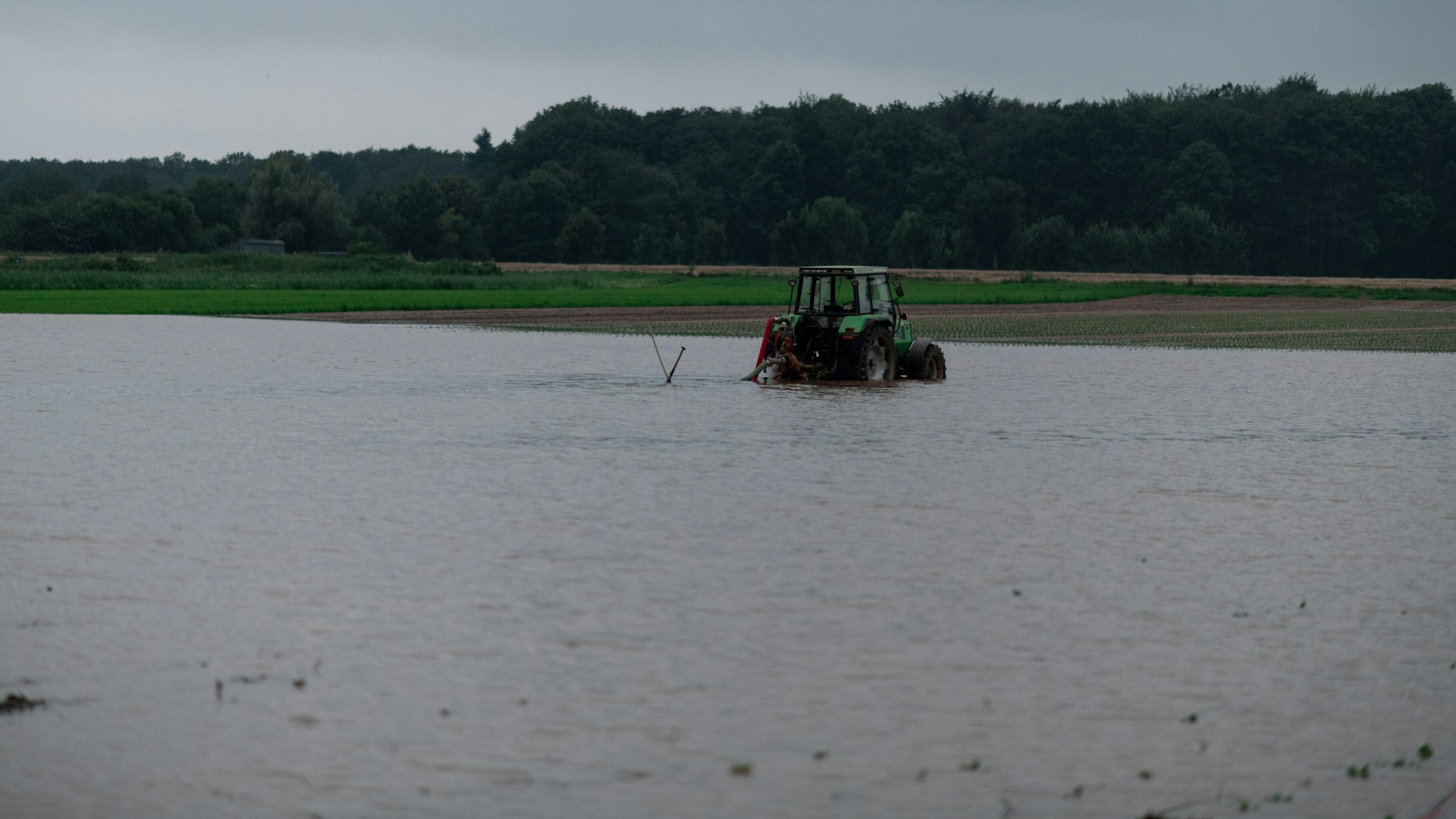 Ein Traktor steht auf einem gefluteten Feld bei Heimerzheim.