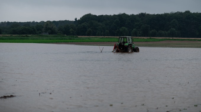 Ein Traktor steht auf einem gefluteten Feld bei Heimerzheim.