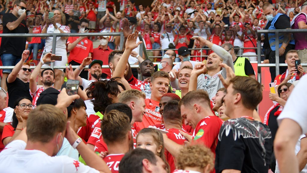 Spieler von Mainz feiern den Sieg gegen Leipzig mit den Fans auf der Tribüne.