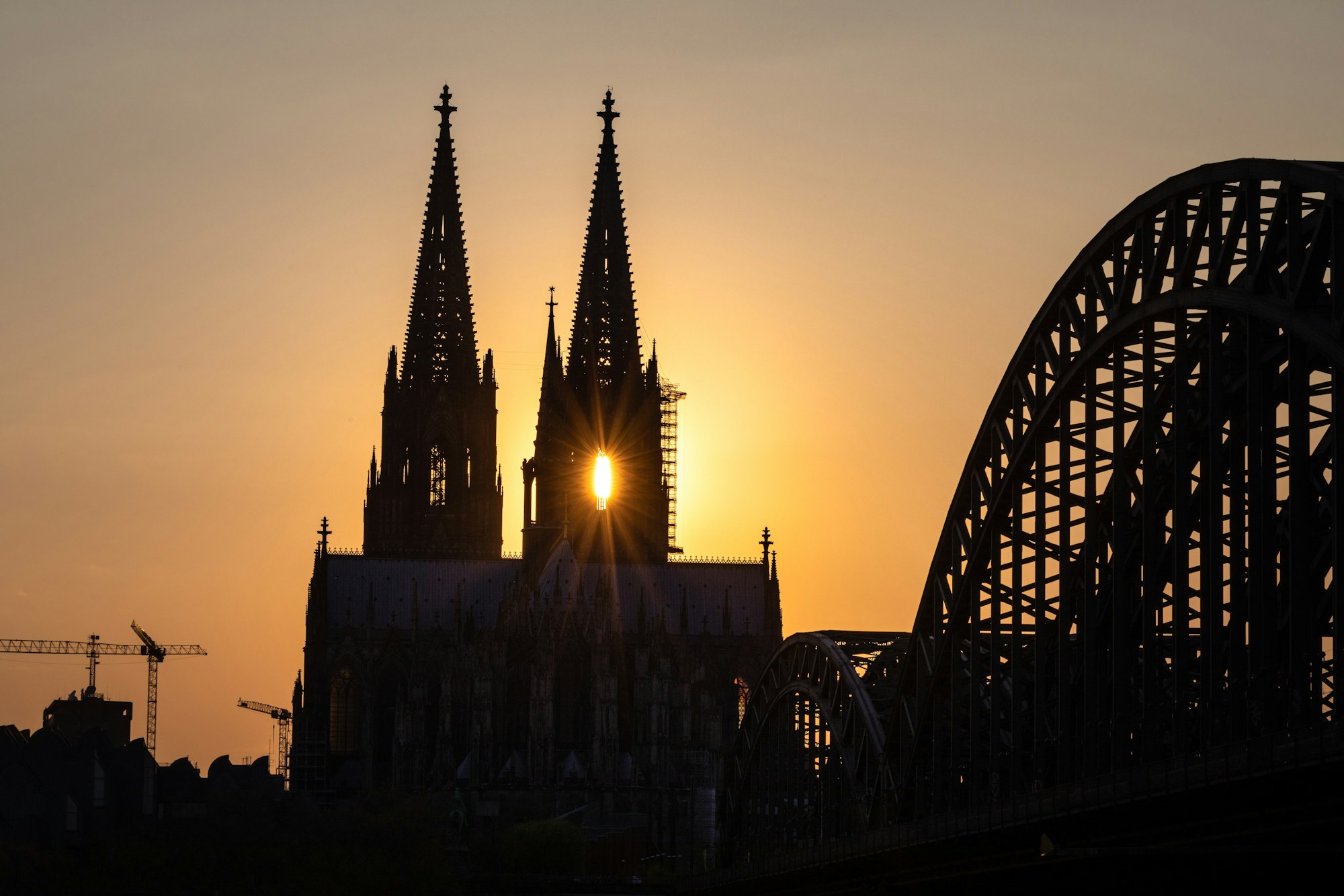 Die Sonne geht hinter dem Kölner Dom (Hohe Domkirche St. Petrus) unter.