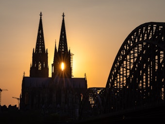 Die Sonne geht hinter dem Kölner Dom unter.
